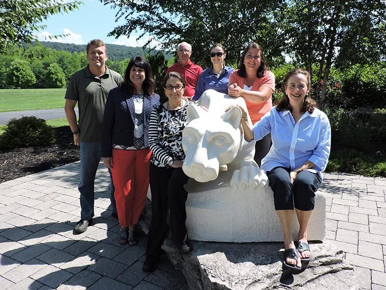 faculty and staff members posing with the nittany lion shrine
