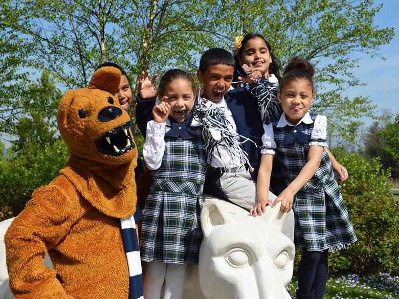young children posing with the nittany lion shrine and the nittany lion mascot