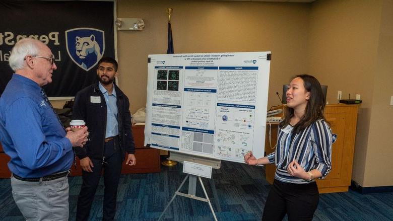 Students present research to faculty member 